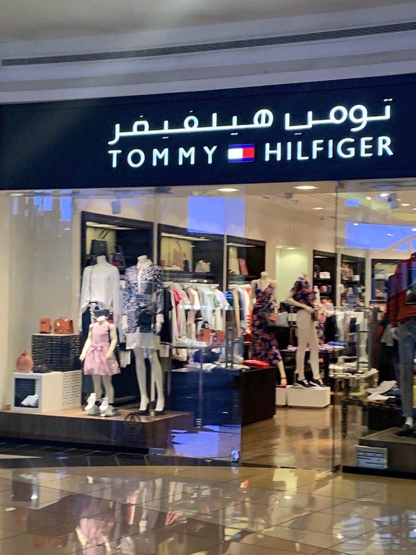 The Tommy Hilfiger store entrance displays mannequins dressed in stylish clothing and accessories.