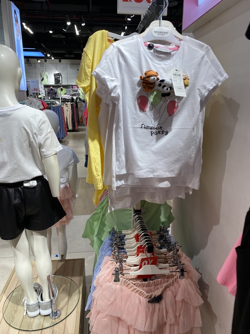 Children's clothing display featuring t-shirts with animal designs and colorful skirts.