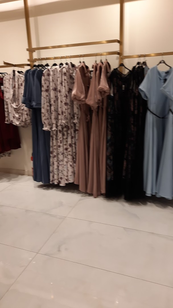 A selection of elegant dresses displayed on a clothing rack in a store.