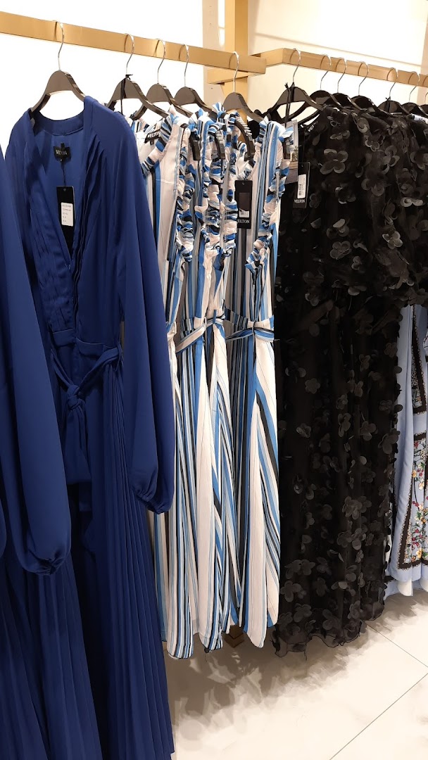 A selection of stylish dresses, including a royal blue pleated dress and a black floral dress.