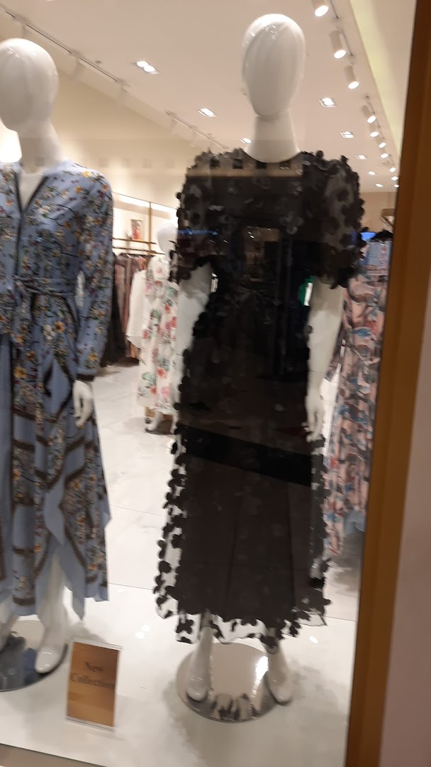 Mannequins display dresses in a shop window, with a 'New Collection' sign visible.