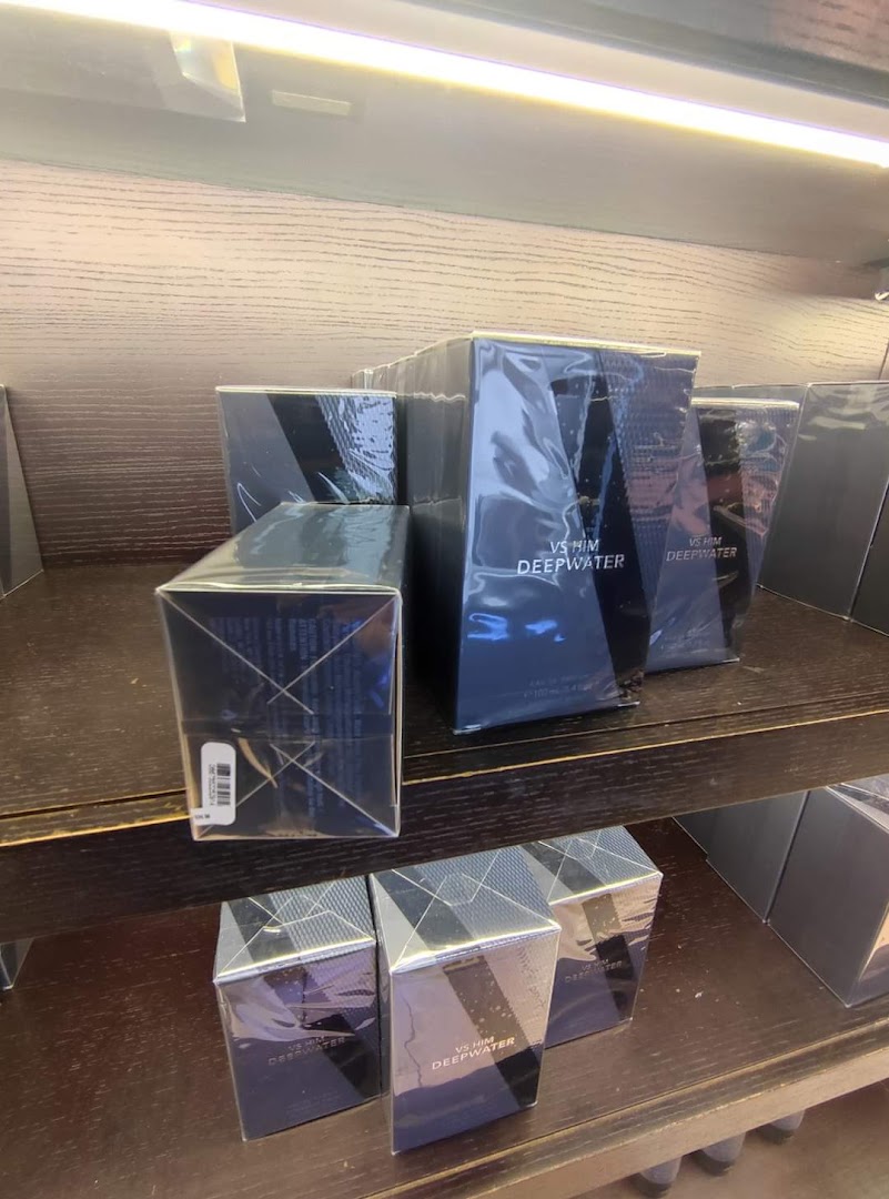 Shelves stocked with VS Him Deepwater perfume boxes, neatly arranged.