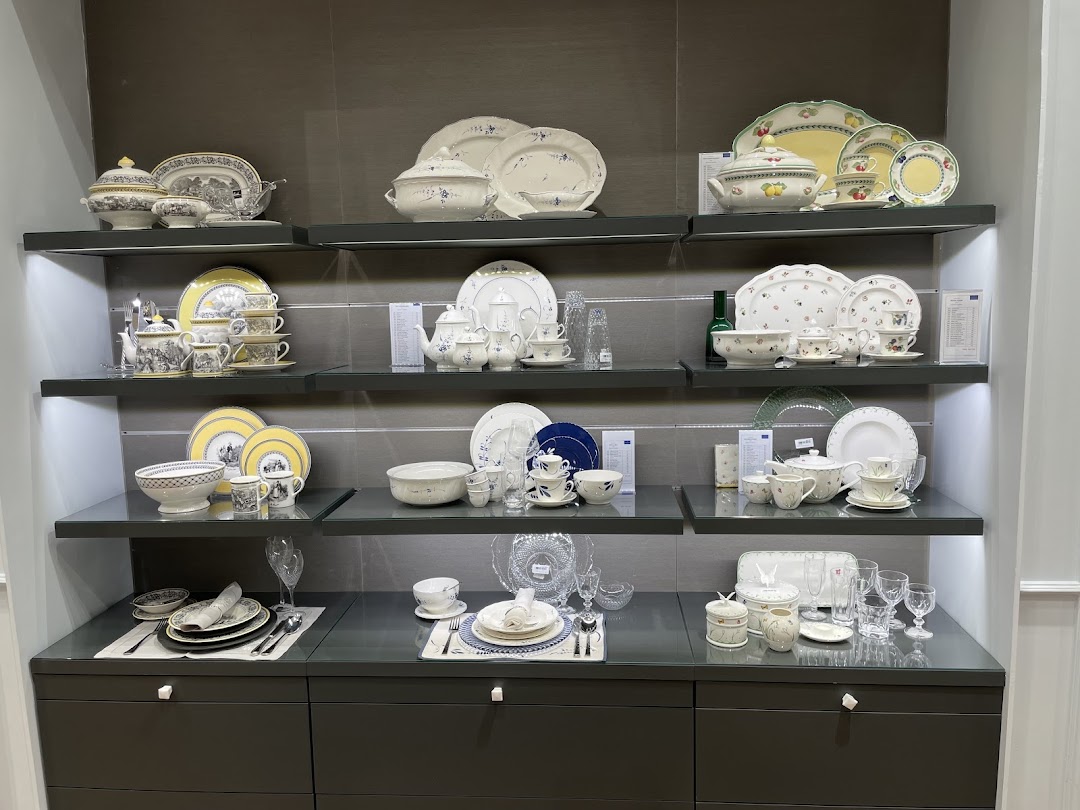Shelves display elegant Villeroy & Boch dinnerware sets, including plates, bowls, cups, and teapots.