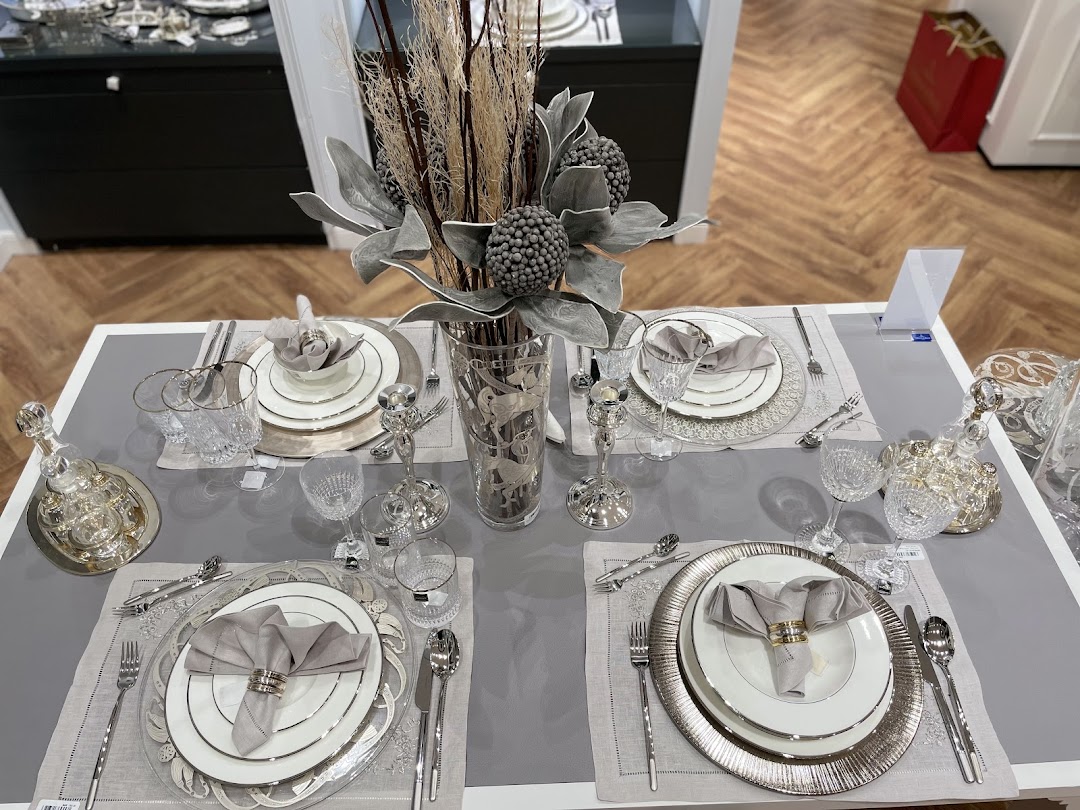 A beautifully set dining table with elegant tableware and a decorative centerpiece.