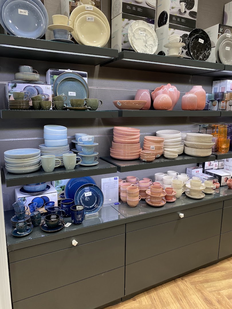 A display of Villeroy & Boch tableware, including plates, bowls, cups, and vases in various colors.