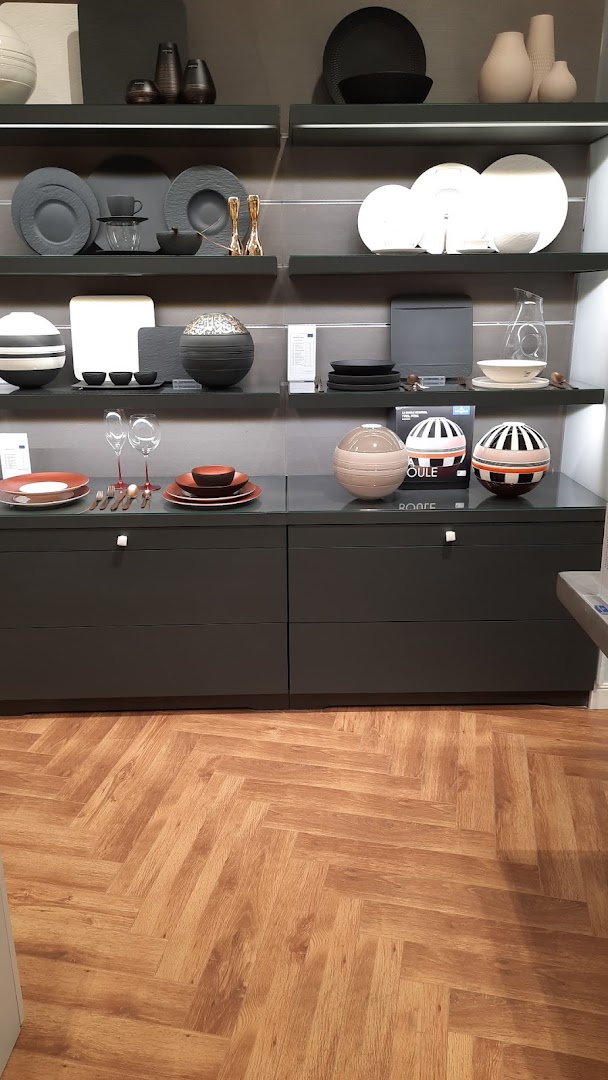A display of Villeroy & Boch tableware and decorative items on shelves and cabinets.