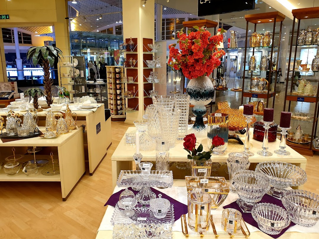 A well-lit retail store showcasing elegant crystalware, tableware, and decorative items.