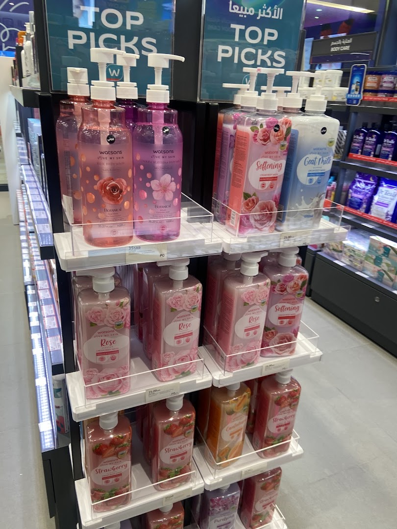 Shelves stocked with various Watsons brand body wash bottles featuring floral and fruit scents.
