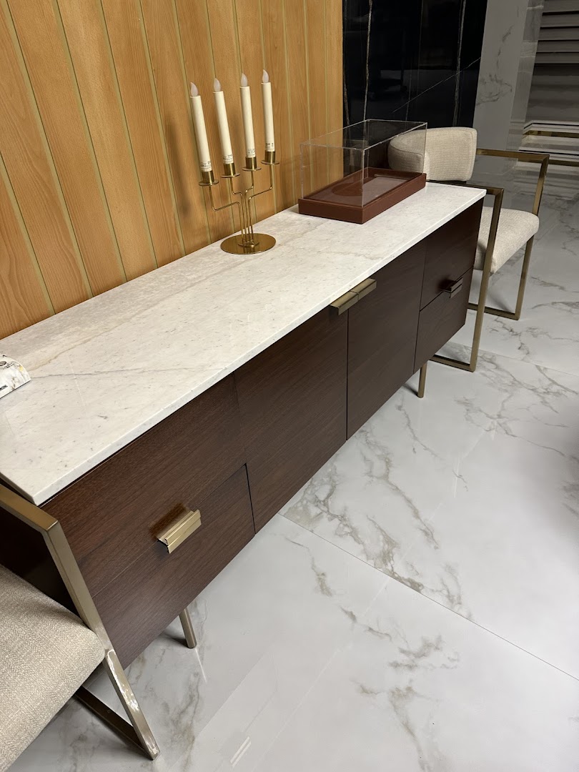 A modern dark wood sideboard with a marble top, featuring a candelabra and display case.
