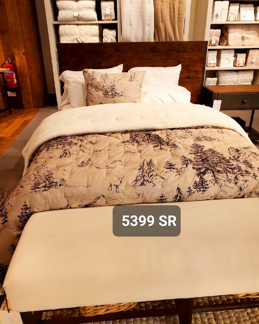 A beautifully made bed with a rustic, nature-themed comforter and pillows, priced at 5399 SR.