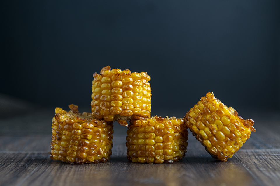 Four pieces of corn on the cob, cut into rounds and stacked.
