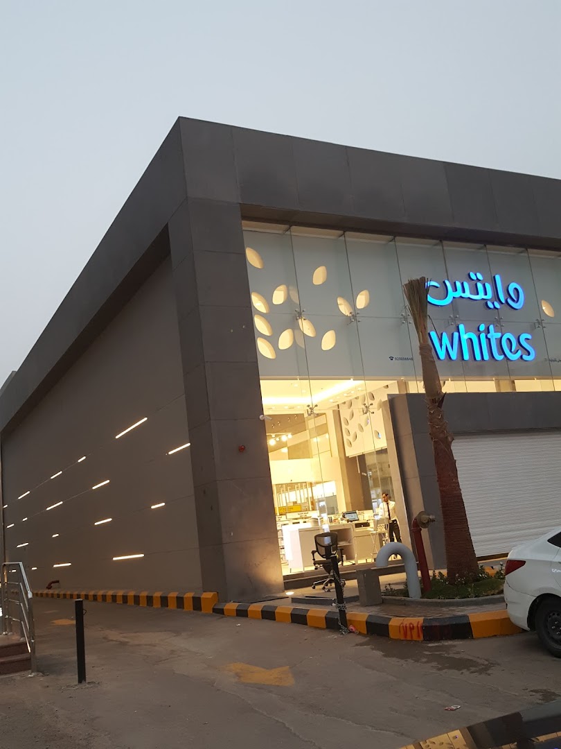 The modern exterior of the Whites shop with large glass windows and illuminated signage.