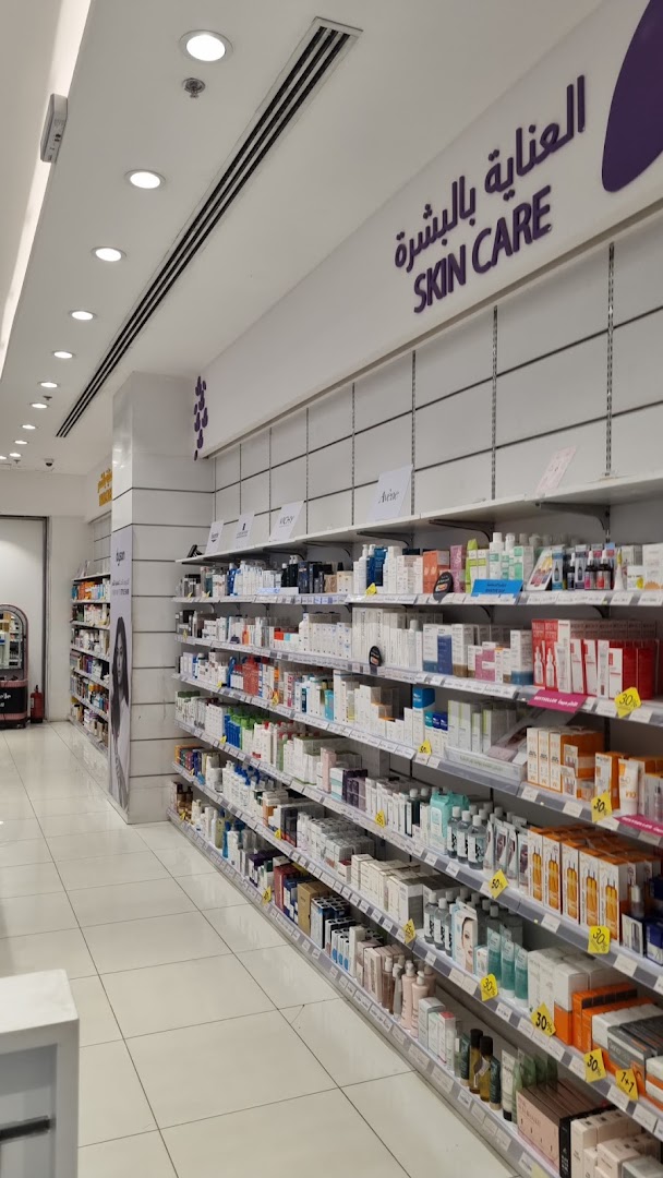 A well-lit pharmacy aisle stocked with a wide variety of skincare products on shelves.