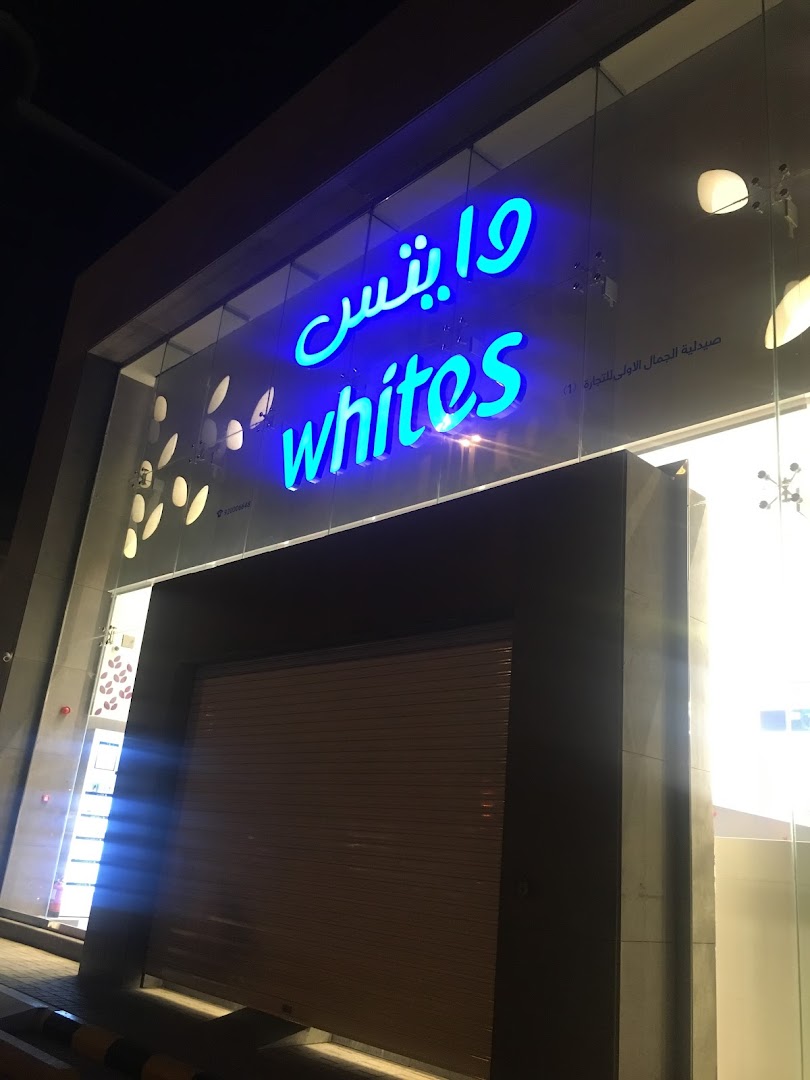 The exterior of a shop named Whites with a prominent blue neon sign.