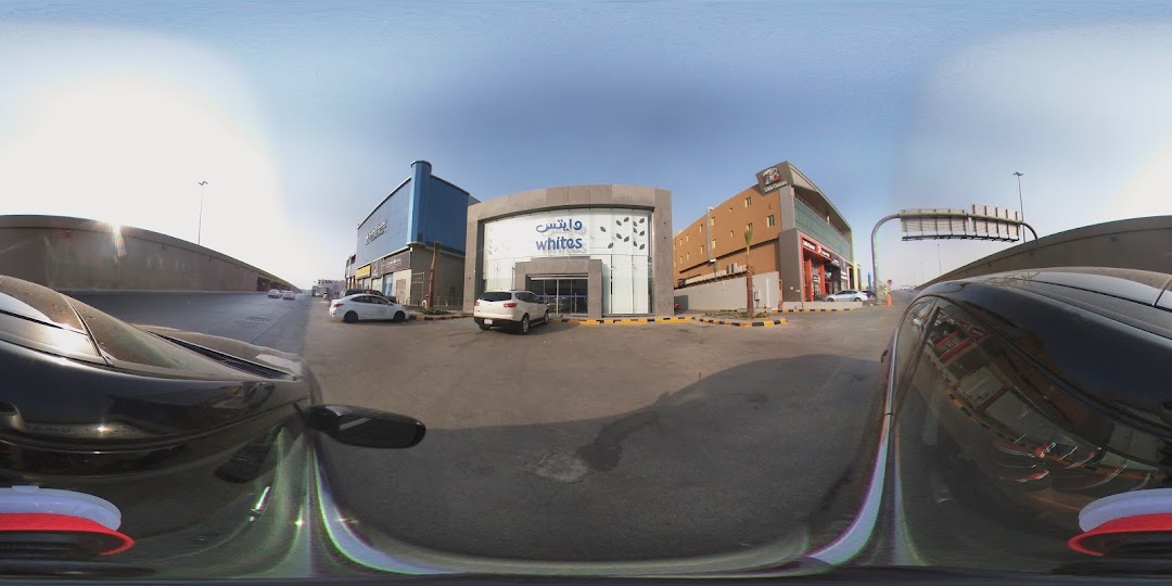 The Whites shop front with a modern facade and glass entrance, featuring cars parked outside.