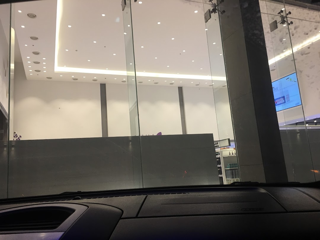 View of a modern shop interior through glass doors, with bright lighting and displays.