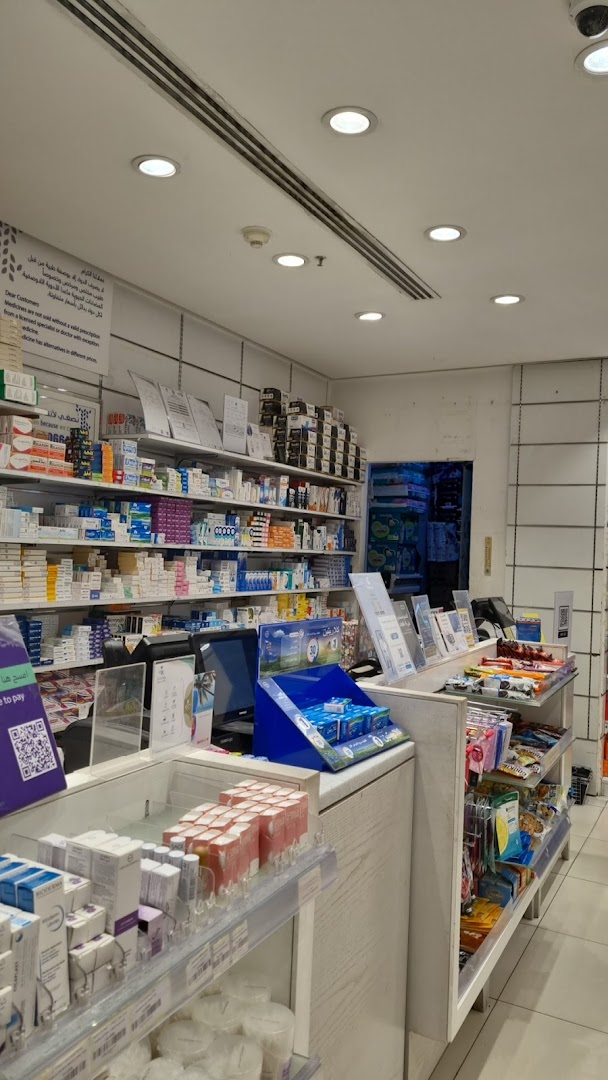 Interior view of a well-stocked pharmacy with shelves full of medicines and health products.