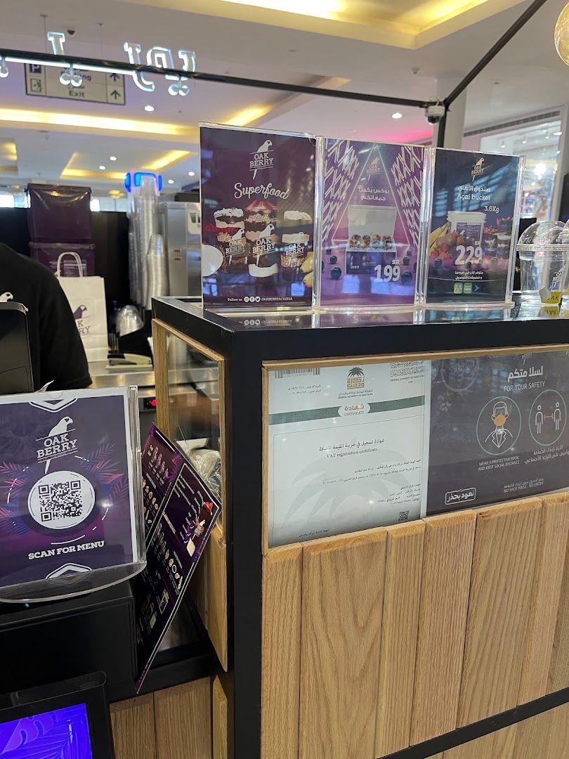 A counter at Oakberry Acai with promotional displays and a QR code for the menu.