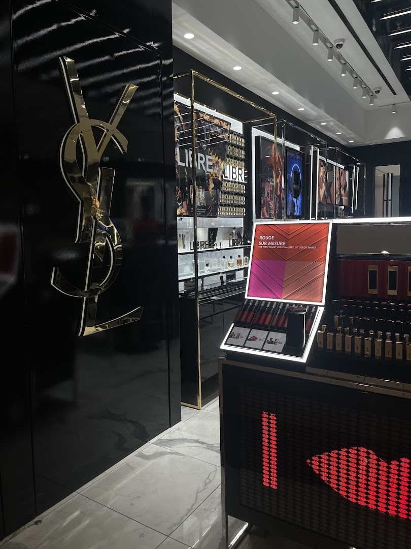 Interior of a YSL Beauty store featuring the iconic YSL logo and displays of makeup products.