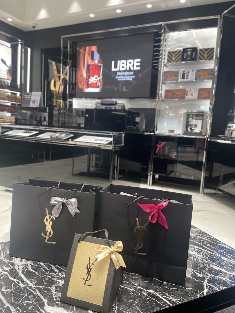 YSL Beauty shopping bags with the iconic logo displayed on a marble surface.