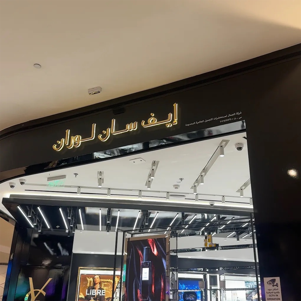 The entrance of a YSL Beauty store with illuminated signage and product displays visible inside.