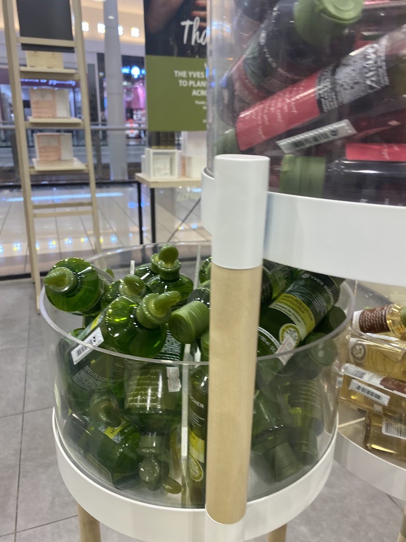 A display of green bottles and other products inside an Yves Rocher store.
