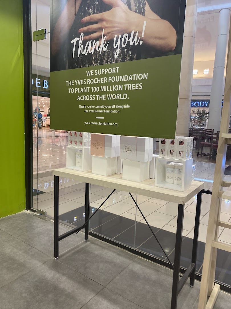 Yves Rocher shop front with a display of products and a banner about planting trees.