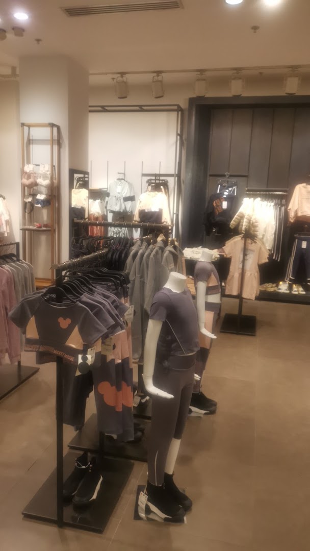 Mannequins dressed in stylish athleisure wear are displayed in a well-lit retail store.