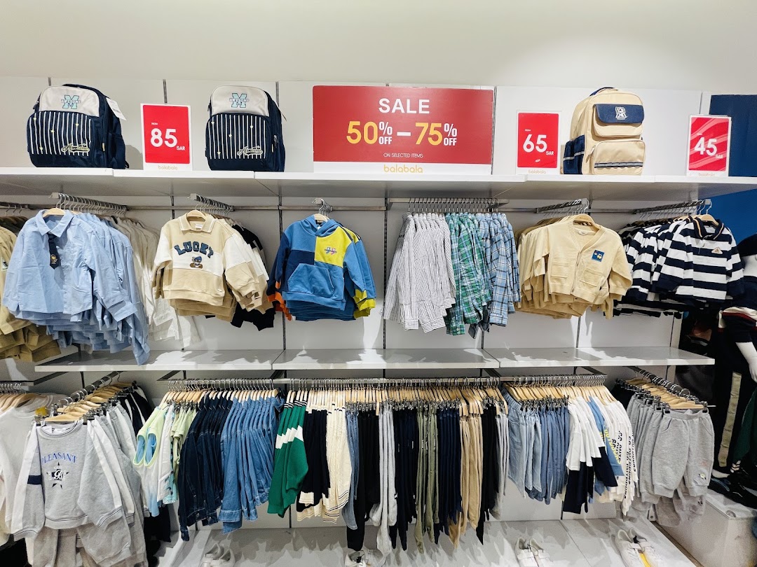 A retail store display featuring children's clothing and backpacks with sale signs.