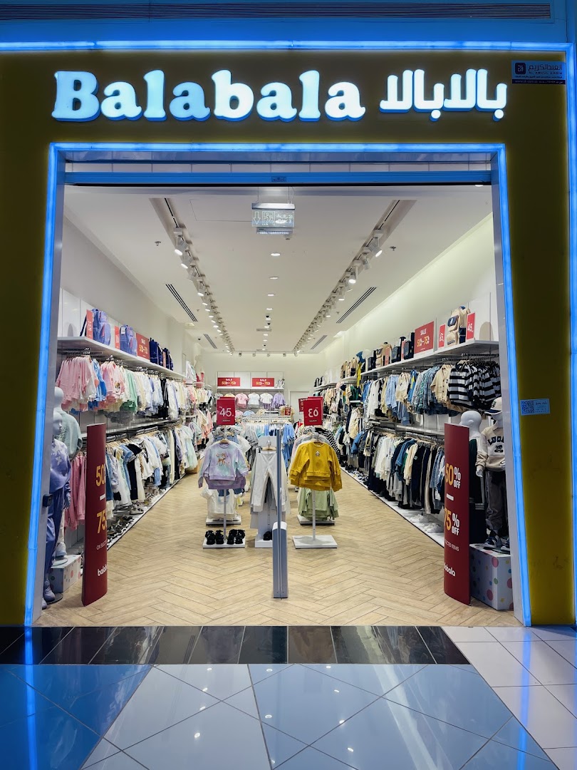 The brightly lit entrance of Balabala, a children's clothing store, showcasing racks of apparel.