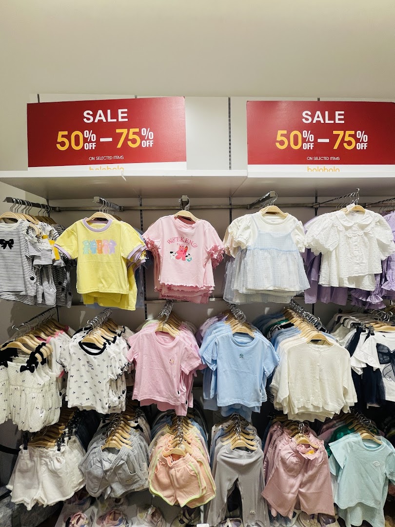 A display of children's clothing with sale signs indicating 50-75% off.