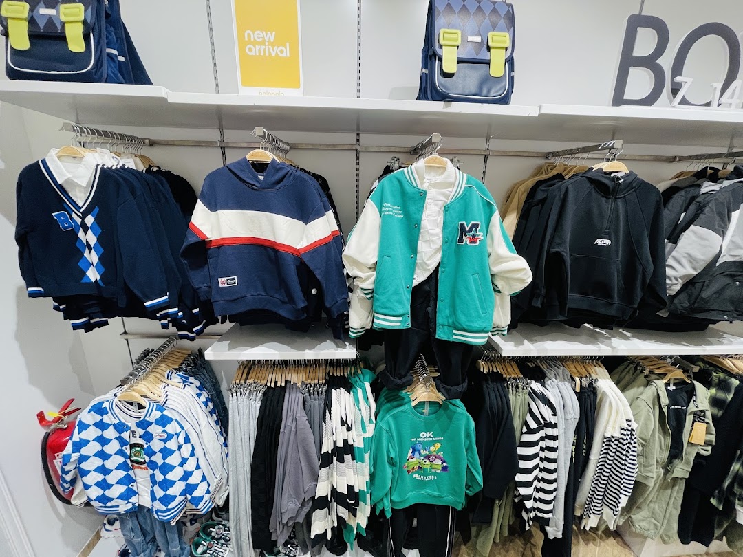 A display of trendy casual wear, including hoodies, jackets, and sweaters, for sale.