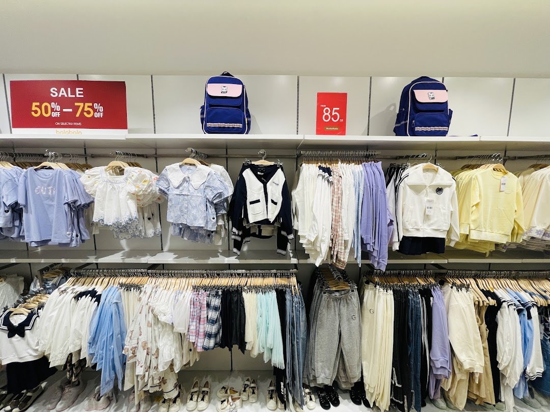 A retail store display featuring children's clothing, backpacks, and sale signs.